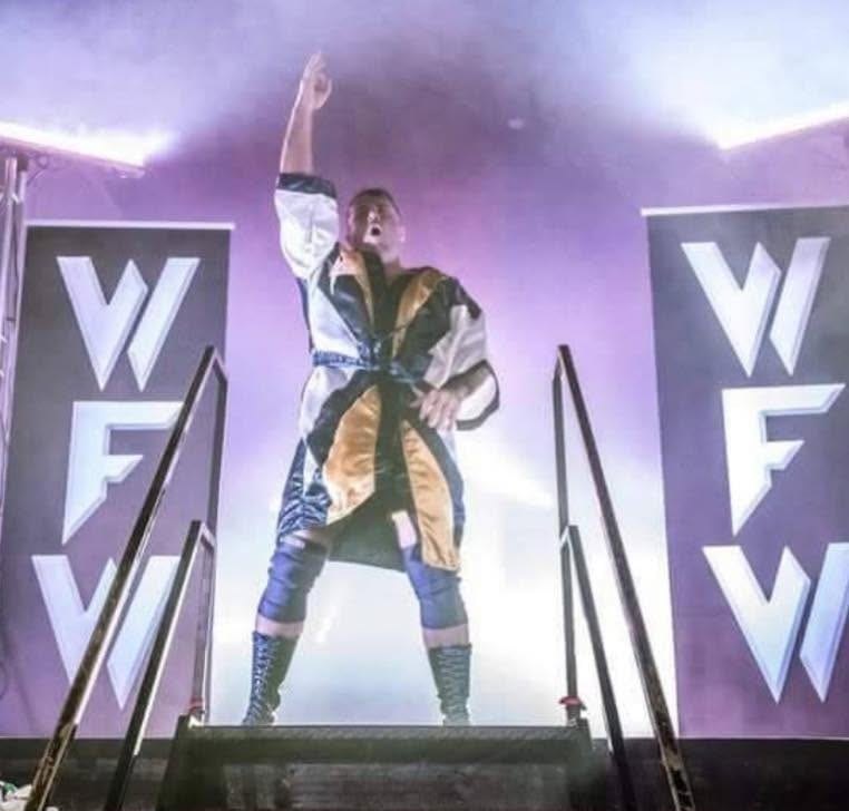 Duke Warfield making his entrance on stage, arm raised